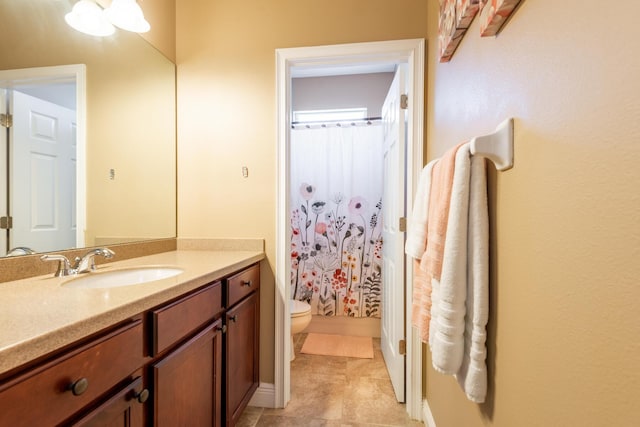 bathroom with tile floors, toilet, and vanity