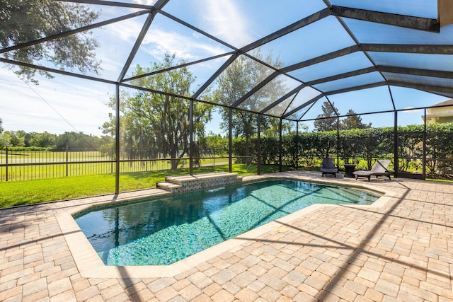 view of pool with a lawn, a patio, and a lanai