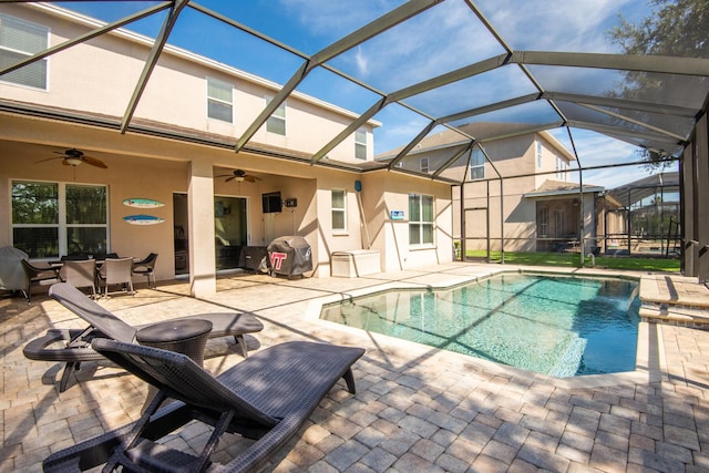 view of pool with pool water feature, ceiling fan, a grill, a patio, and a lanai