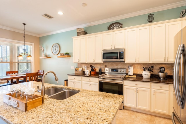 kitchen featuring sink, hanging light fixtures, appliances with stainless steel finishes, a chandelier, and dark stone countertops