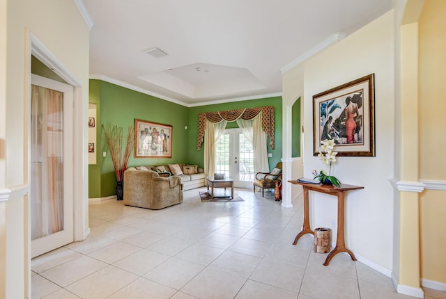 interior space with french doors, crown molding, decorative columns, light tile flooring, and a tray ceiling