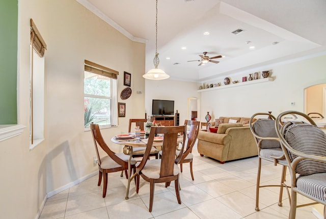 tiled dining room with a raised ceiling and ceiling fan