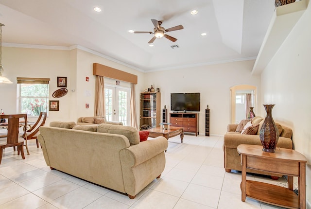 tiled living room with a raised ceiling, ornamental molding, ceiling fan, and french doors