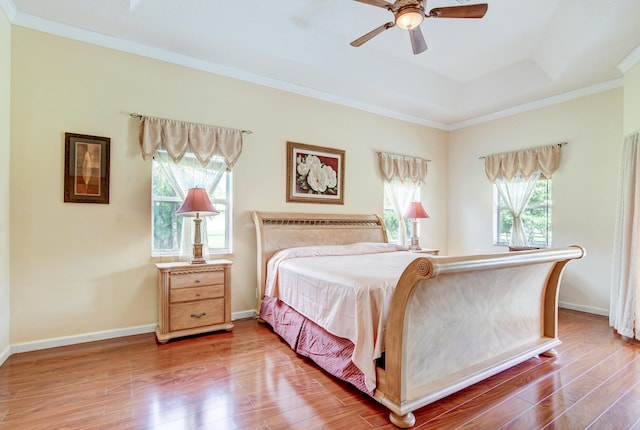 bedroom with ceiling fan, multiple windows, wood-type flooring, and crown molding