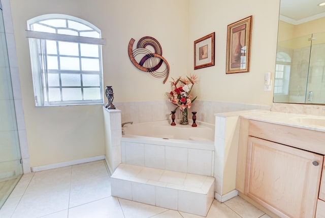 bathroom with ornamental molding, vanity, tile flooring, and tiled bath