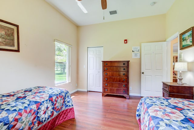 bedroom featuring ceiling fan, high vaulted ceiling, and dark wood-type flooring