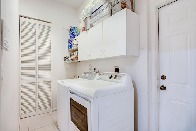 laundry room with light tile floors, independent washer and dryer, hookup for an electric dryer, and cabinets