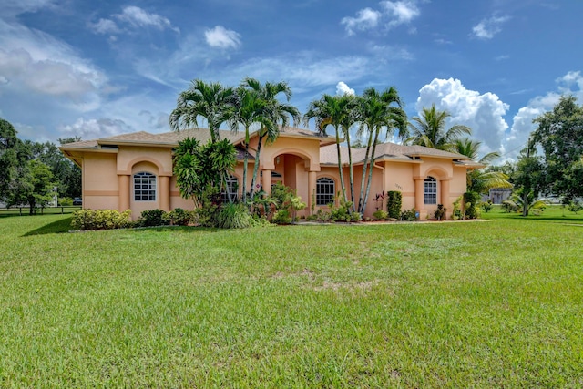 mediterranean / spanish home featuring a front lawn