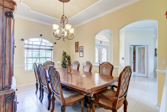 tiled dining area with an inviting chandelier, french doors, and ornamental molding