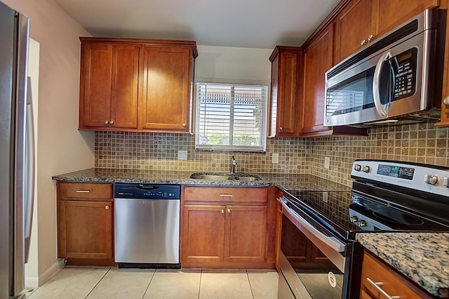 200 Waterway Dr S Unit 102, Lantana, FL 33462 - kitchen featuring backsplash, appliances with stainless steel finishes, sink, dark stone countertops, and light tile floors