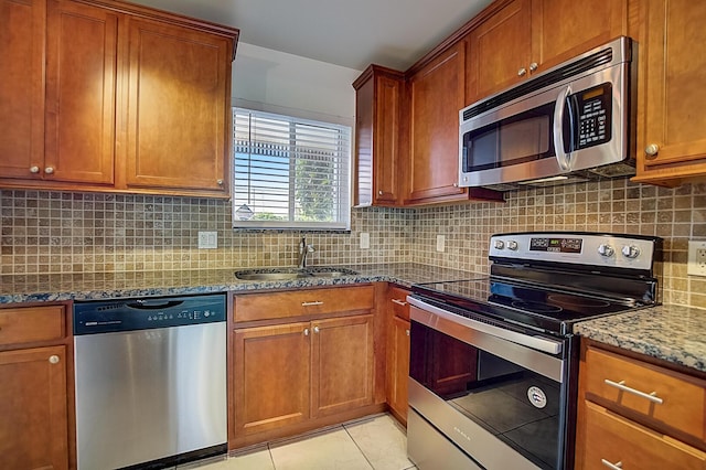 200 Waterway Dr S Unit 102, Lantana, FL 33462 - kitchen with backsplash, appliances with stainless steel finishes, sink, light tile floors, and dark stone counters