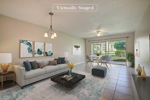 tiled living room with a textured ceiling and ceiling fan with notable chandelier