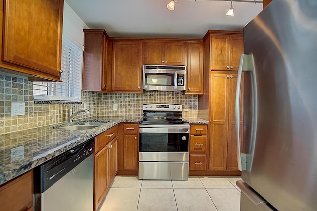 200 Waterway Dr S Unit 102, Lantana, FL 33462 - kitchen featuring sink, light tile floors, dark stone countertops, backsplash, and stainless steel appliances
