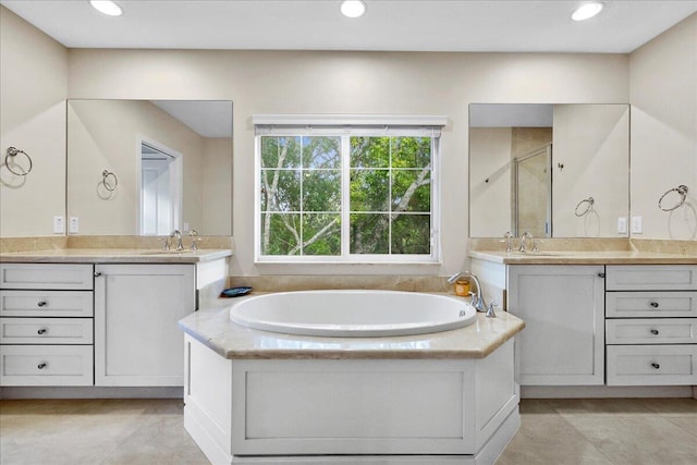 bathroom featuring tile flooring, dual vanity, and a tub