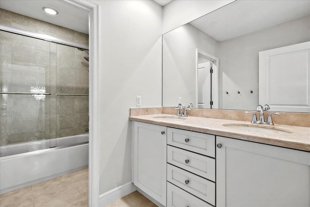 bathroom featuring combined bath / shower with glass door, double sink, tile flooring, and vanity with extensive cabinet space