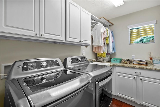 laundry room with dark wood-type flooring, cabinets, sink, and washing machine and dryer