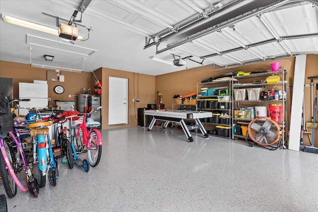 garage featuring a garage door opener, a workshop area, and water heater