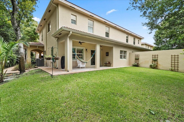 rear view of house featuring central AC unit, a patio area, and a yard