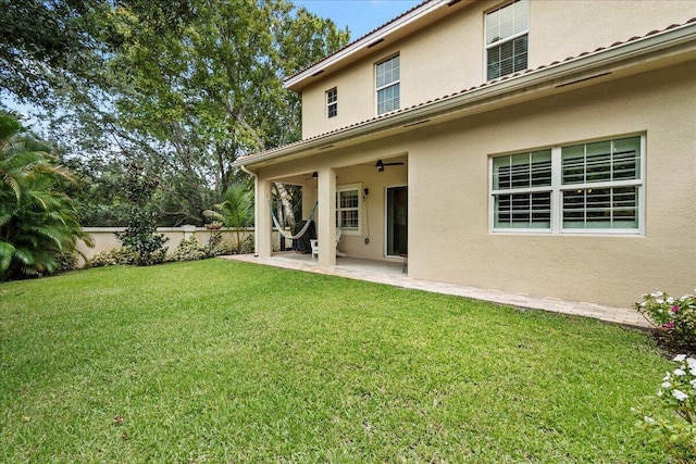 rear view of house featuring a lawn, a patio area, and ceiling fan