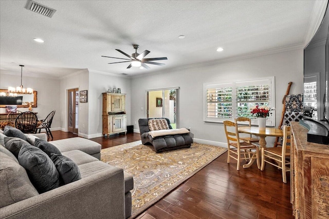 living room with ornamental molding, dark hardwood / wood-style flooring, a textured ceiling, and ceiling fan with notable chandelier