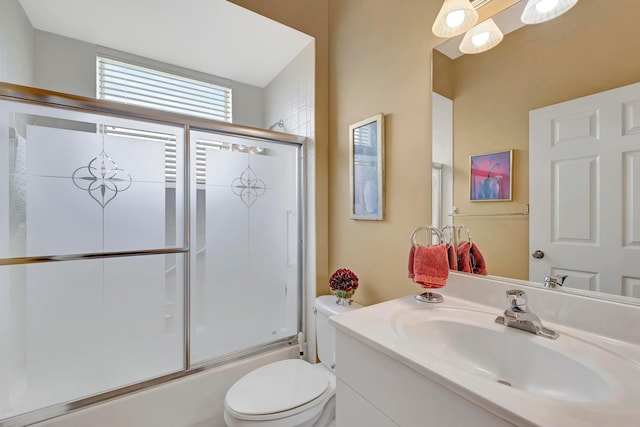 full bathroom featuring vanity, shower / bath combination with glass door, and toilet