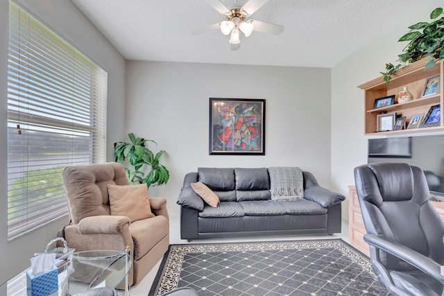 carpeted living room with plenty of natural light, a textured ceiling, and ceiling fan