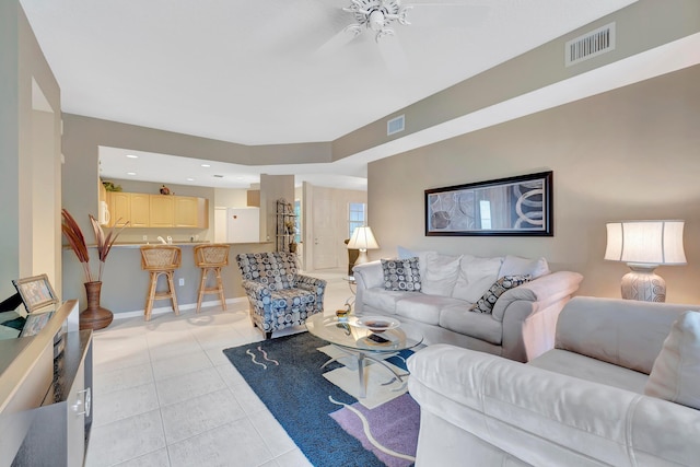 living room featuring light tile floors and ceiling fan