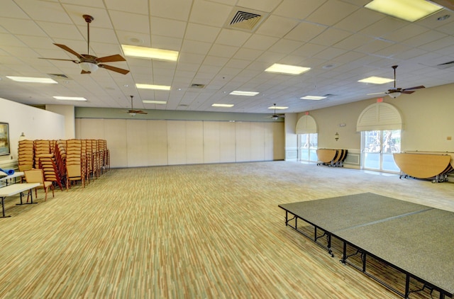 misc room featuring a paneled ceiling, light carpet, and ceiling fan