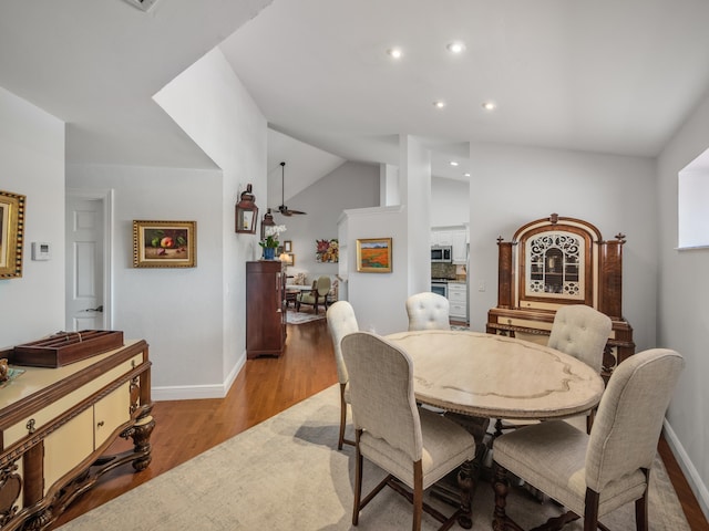 dining area featuring lofted ceiling and light wood-type flooring