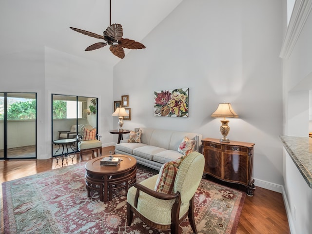 living room with high vaulted ceiling, ceiling fan, and dark wood-type flooring