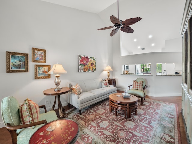 living room with high vaulted ceiling, sink, ceiling fan, and hardwood / wood-style flooring