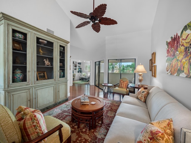 living room with ceiling fan, high vaulted ceiling, and dark wood-type flooring