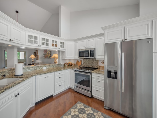 kitchen featuring high vaulted ceiling, stainless steel appliances, white cabinetry, and dark hardwood / wood-style flooring