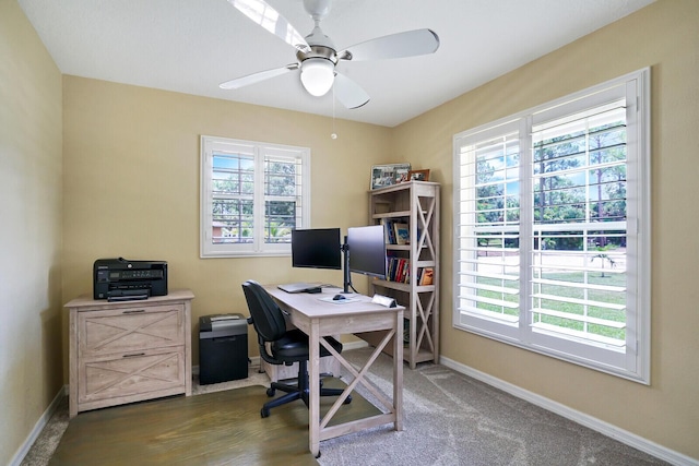 carpeted office featuring plenty of natural light and ceiling fan