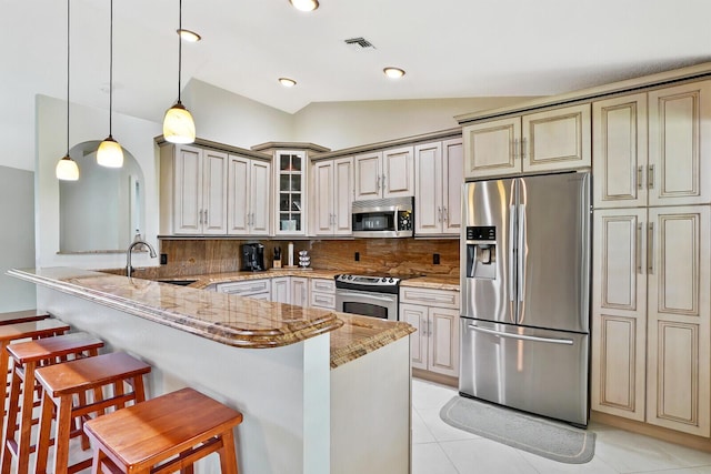 kitchen with decorative light fixtures, a breakfast bar, tasteful backsplash, appliances with stainless steel finishes, and sink