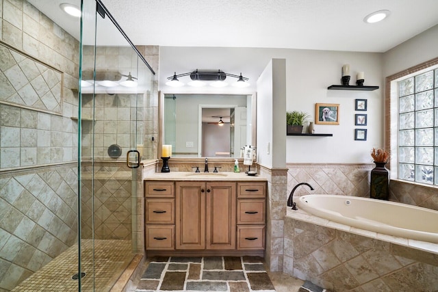 bathroom with plus walk in shower, tile floors, vanity, and a wealth of natural light