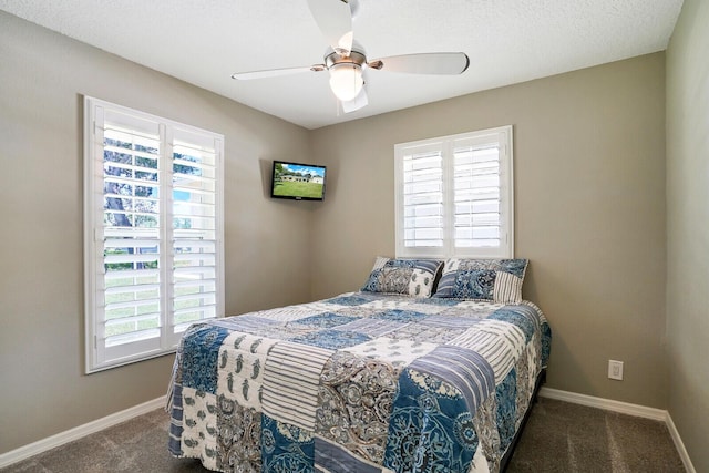 bedroom with a textured ceiling, ceiling fan, and dark carpet