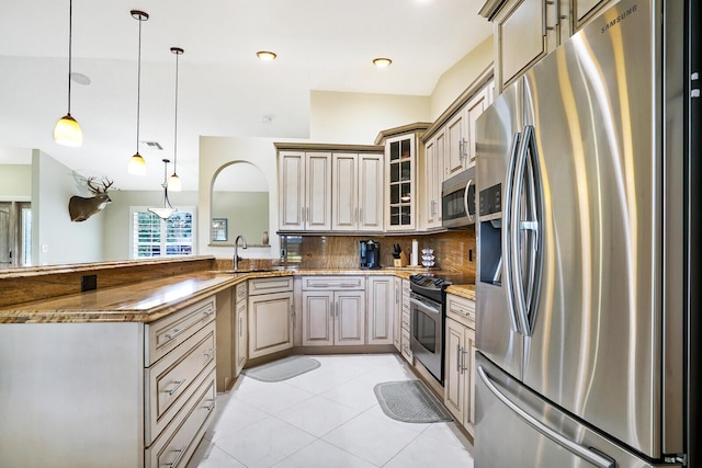 kitchen with pendant lighting, stainless steel appliances, light tile floors, tasteful backsplash, and sink