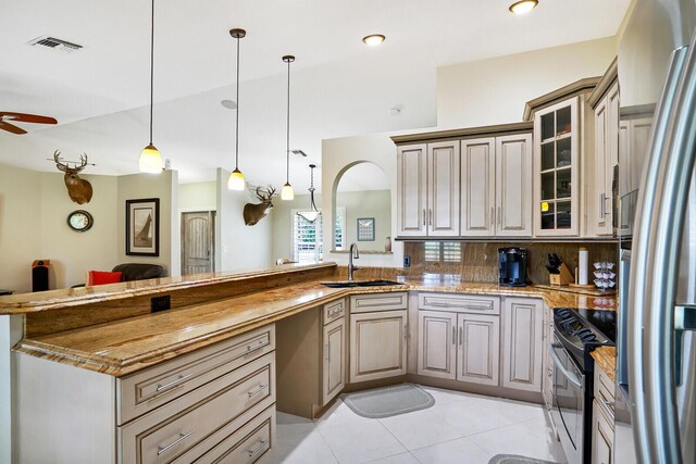 kitchen with pendant lighting, ceiling fan, light tile floors, backsplash, and stainless steel appliances