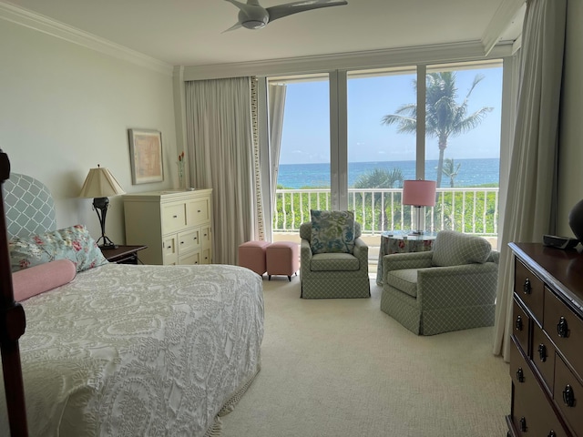 carpeted bedroom with a water view, ornamental molding, ceiling fan, and multiple windows