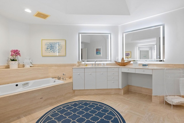 bathroom featuring double vanity and tiled bath