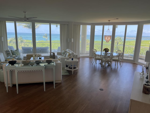 living room featuring a water view, ceiling fan with notable chandelier, and dark hardwood / wood-style flooring