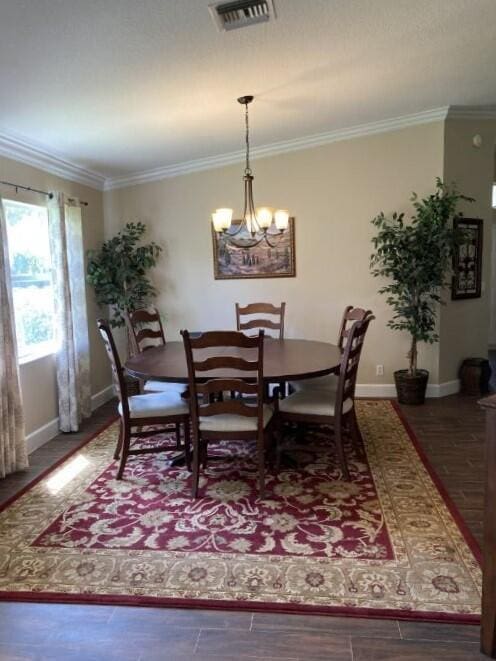 dining area with a chandelier and crown molding