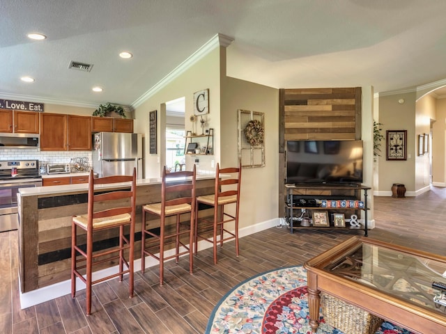 kitchen with dark hardwood / wood-style floors, crown molding, backsplash, stainless steel appliances, and lofted ceiling