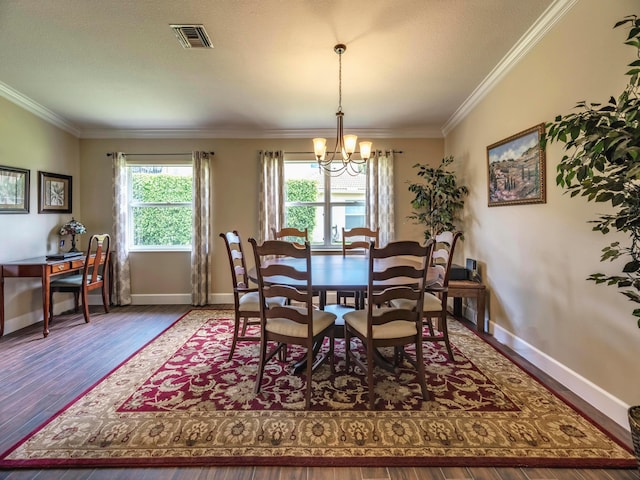 dining space featuring dark hardwood / wood-style floors, ornamental molding, and a chandelier