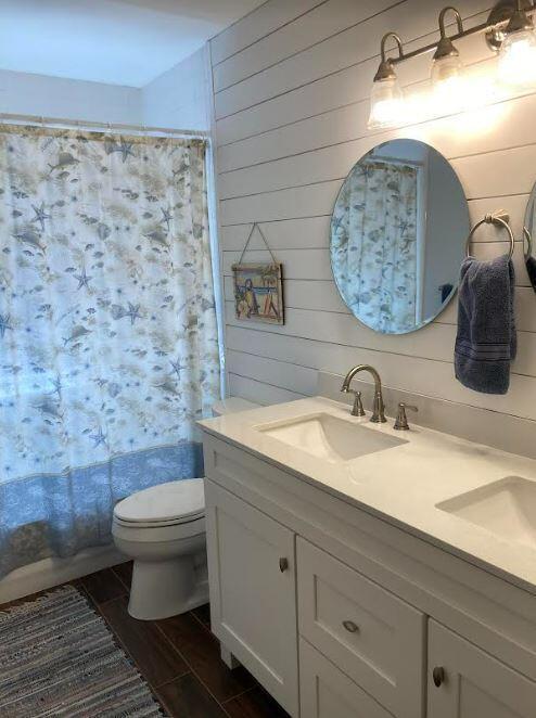 bathroom featuring toilet and double vanity