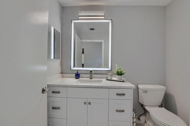 bathroom featuring toilet and vanity