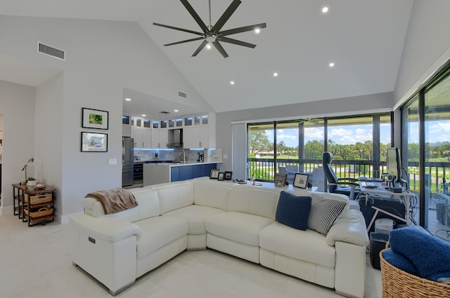 tiled living room featuring high vaulted ceiling, ceiling fan, and sink