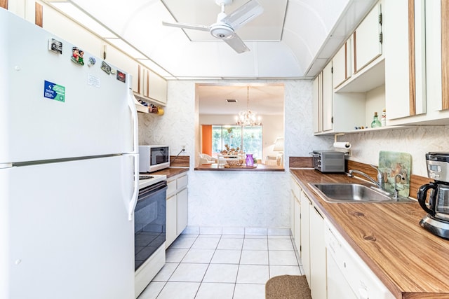 kitchen featuring white cabinets, white appliances, sink, and ceiling fan with notable chandelier