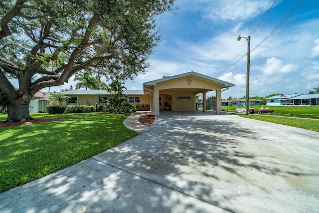 ranch-style home featuring a carport and a front yard